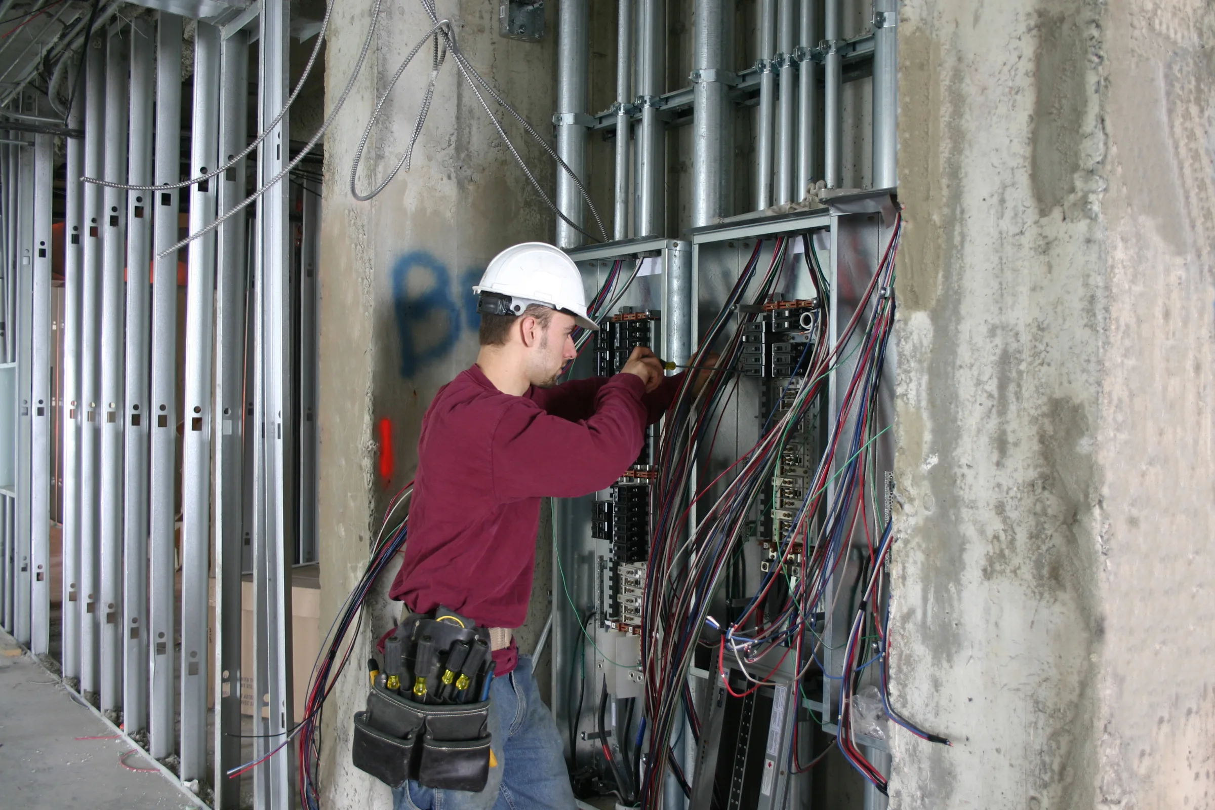 Electrician working on industrial control panel with precise wiring